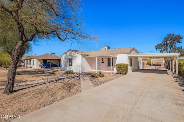 ranch-style house with driveway, a carport, and stucco siding