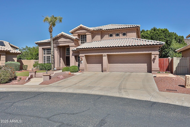 view of front of house with concrete driveway, fence, a tile roof, and stucco siding