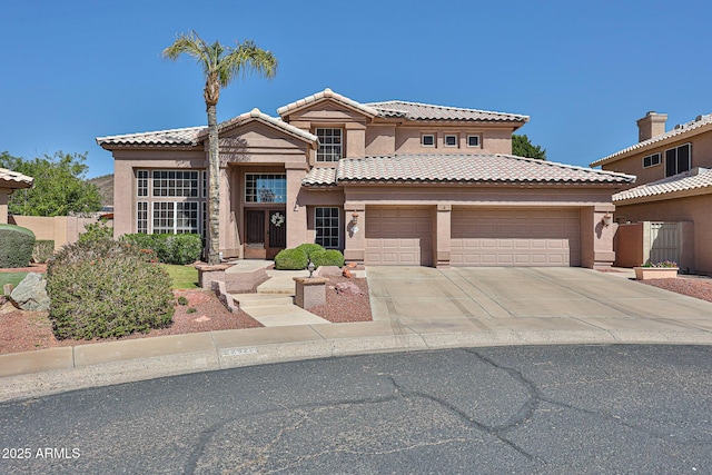 view of front facade with a tiled roof, an attached garage, driveway, and stucco siding