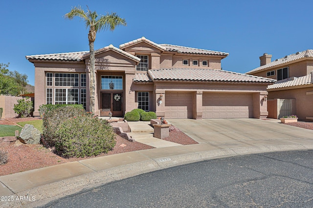 mediterranean / spanish house with stucco siding, a garage, concrete driveway, and a tile roof