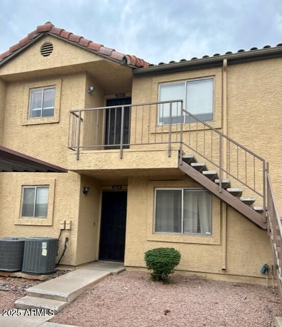 653 W Guadalupe Rd Unit 2019, Mesa, AZ 85210 - view of front facade with a balcony, central AC unit, stucco siding, and a tile roof