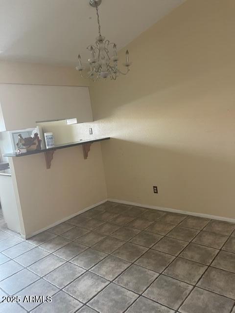 653 W Guadalupe Rd Unit 2019, Mesa, AZ 85210 - kitchen with a kitchen breakfast bar, a chandelier, baseboards, vaulted ceiling, and tile patterned flooring