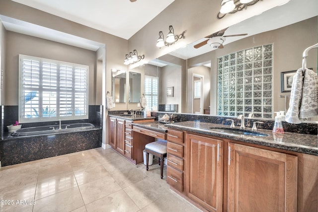 bathroom with ceiling fan, a relaxing tiled tub, vanity, and tile patterned flooring