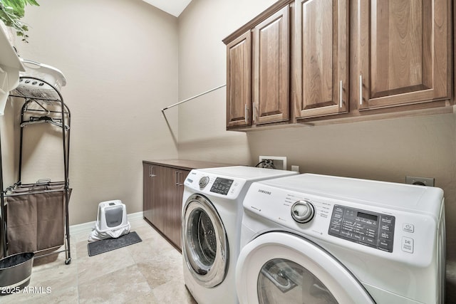 laundry room featuring washing machine and dryer and cabinets