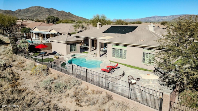 back of house featuring a patio area, a fenced in pool, and a mountain view