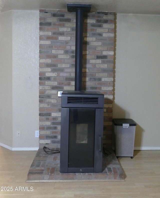 details with wood finished floors, a wood stove, and baseboards