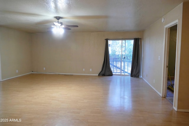 empty room featuring light wood finished floors, ceiling fan, baseboards, and a textured ceiling