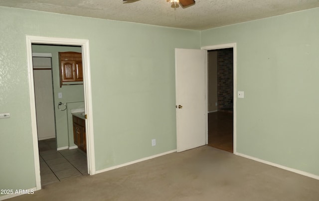 unfurnished bedroom featuring a textured ceiling and ensuite bathroom