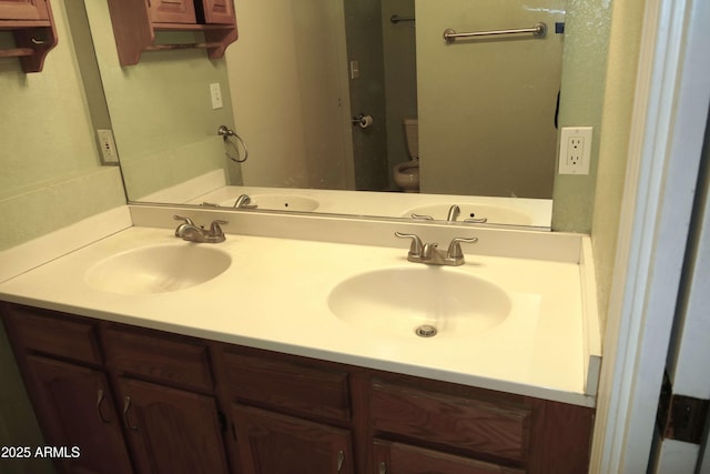 full bath with a sink, toilet, and double vanity