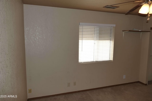 empty room featuring a ceiling fan and baseboards