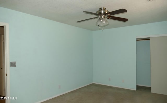 unfurnished bedroom with a textured ceiling, ceiling fan, a closet, and baseboards