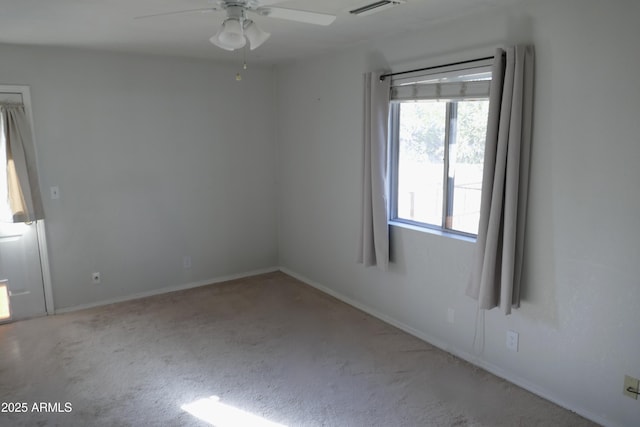 unfurnished room with baseboards, visible vents, and a ceiling fan