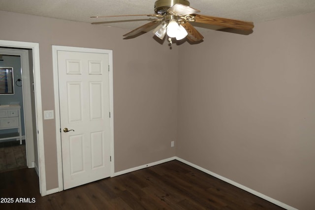 unfurnished bedroom featuring a textured ceiling, dark wood-style flooring, a ceiling fan, and baseboards