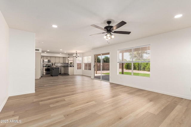 1202 E Libby St, Phoenix, AZ 85022 - unfurnished living room with a chandelier, a ceiling fan, recessed lighting, baseboards, and light wood-style flooring