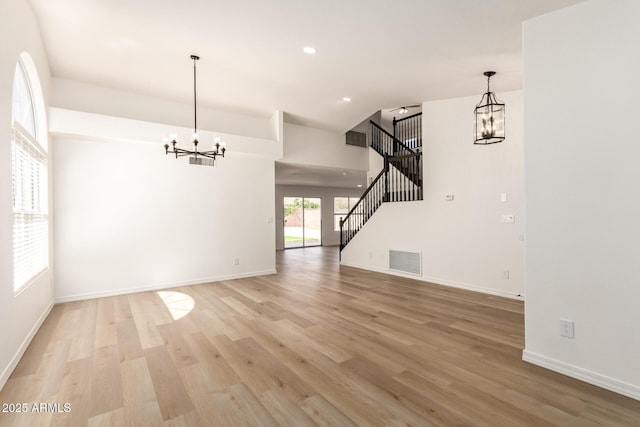 1202 E Libby St, Phoenix, AZ 85022 - unfurnished living room with a chandelier, light wood-style floors, stairway, baseboards, and recessed lighting