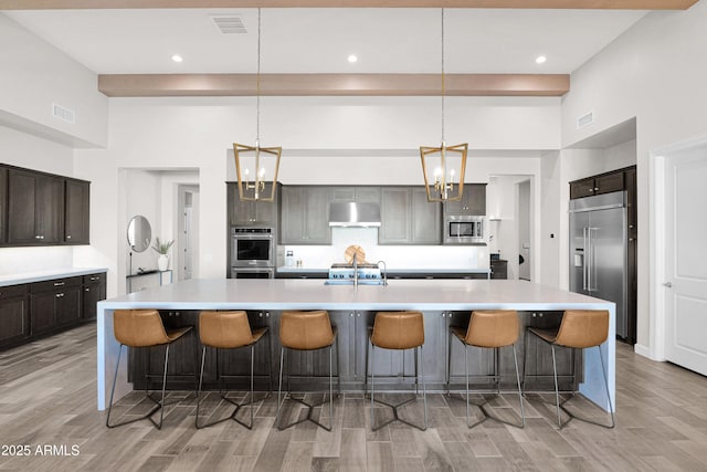 kitchen featuring built in appliances, a kitchen breakfast bar, and a spacious island