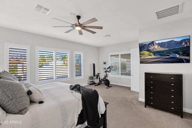 bedroom featuring ceiling fan, light colored carpet, and multiple windows