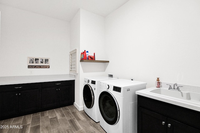 washroom with sink, cabinets, and washer and clothes dryer