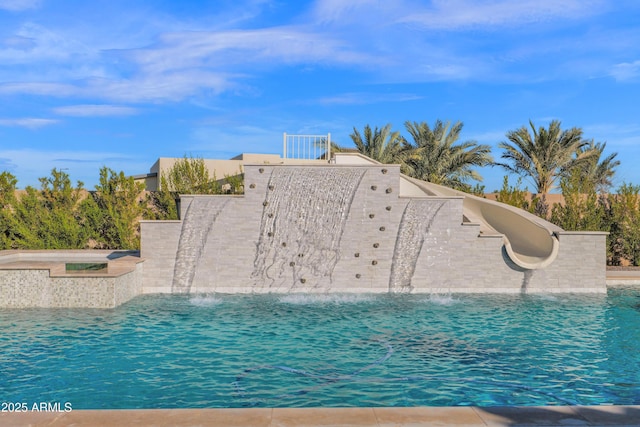 view of swimming pool featuring a water slide and pool water feature