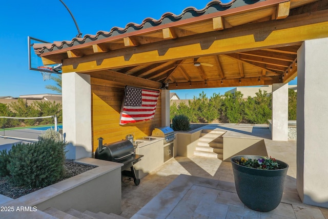 view of patio featuring exterior kitchen, a gazebo, and grilling area