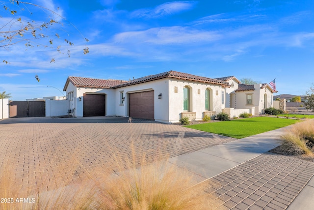 mediterranean / spanish-style house with a garage and a front yard