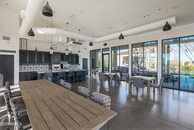 dining room featuring a towering ceiling