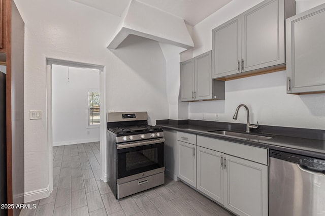 430 N 17th Ave, Phoenix, AZ 85007 - kitchen with appliances with stainless steel finishes, dark countertops, wood finish floors, and gray cabinets