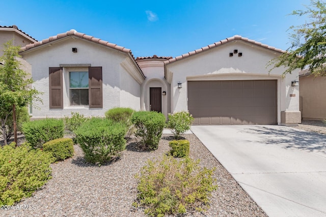 mediterranean / spanish house featuring stucco siding, a garage, and concrete driveway