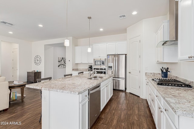 kitchen with dark wood finished floors, wall chimney range hood, visible vents, and appliances with stainless steel finishes