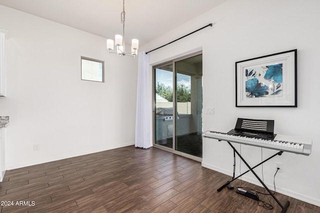 interior space featuring an inviting chandelier, dark wood-type flooring, and baseboards