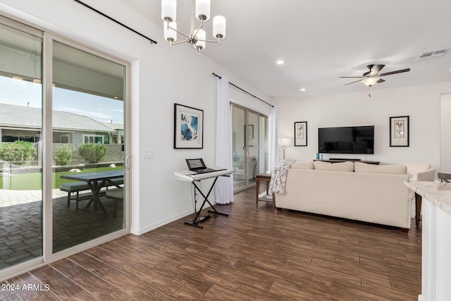 living area with visible vents, ceiling fan with notable chandelier, dark wood finished floors, recessed lighting, and baseboards