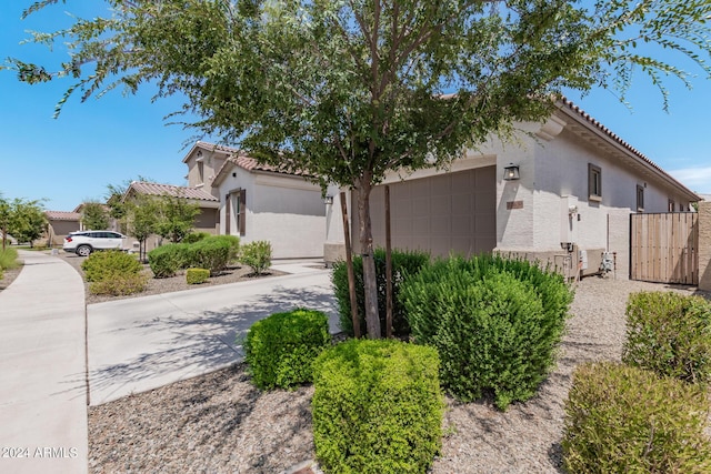 view of front of home with stucco siding, concrete driveway, an attached garage, and a tiled roof