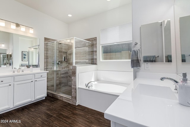 bathroom with vanity, a garden tub, wood finished floors, and a stall shower