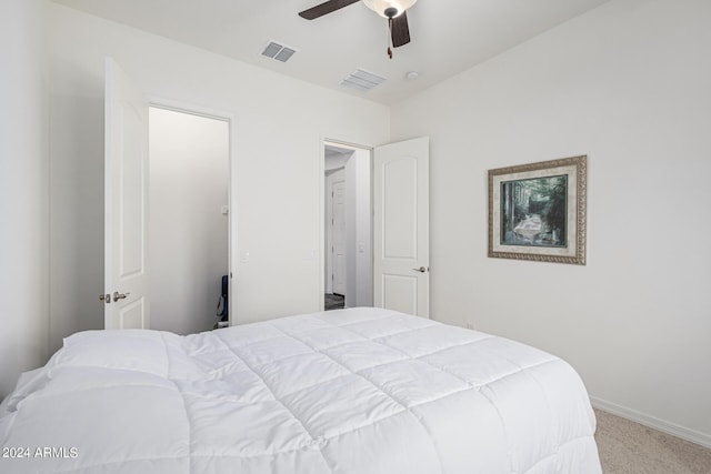 carpeted bedroom with visible vents, baseboards, and a ceiling fan