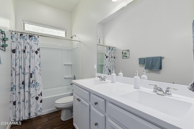 full bath featuring a sink, shower / bathtub combination with curtain, toilet, and wood finished floors