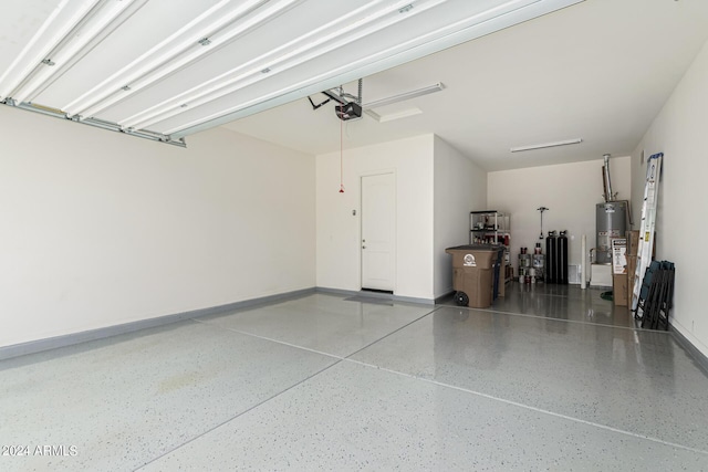 garage featuring gas water heater, a garage door opener, and baseboards