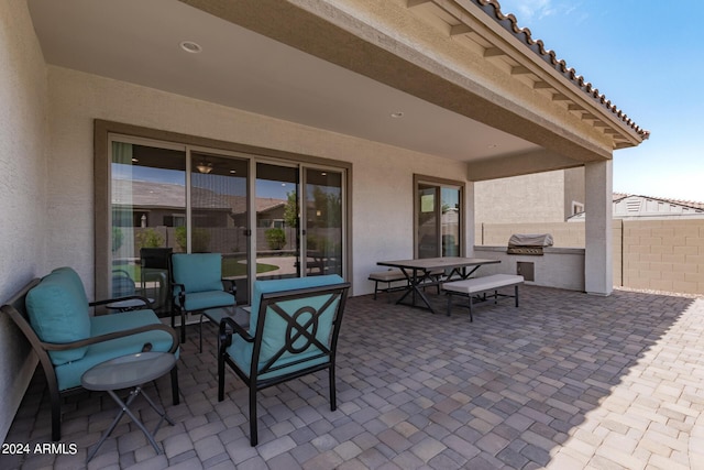 view of patio / terrace with outdoor dining area, a grill, exterior kitchen, and fence