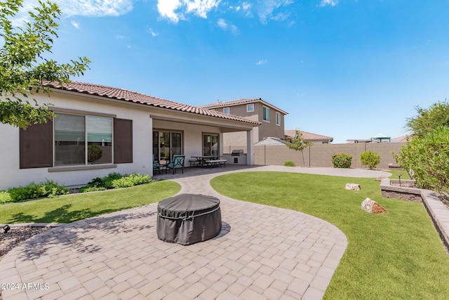 rear view of house with fence, a tiled roof, an outdoor fire pit, stucco siding, and a patio