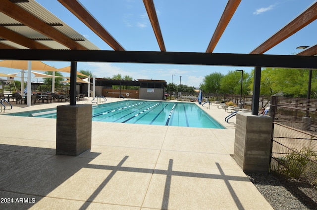 pool with a patio area and fence