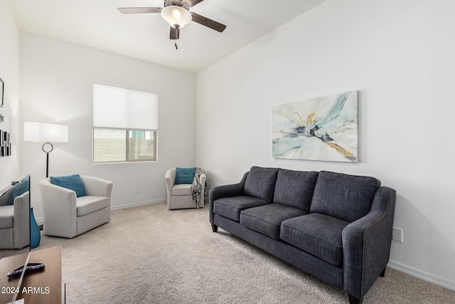 living area with carpet, baseboards, and ceiling fan