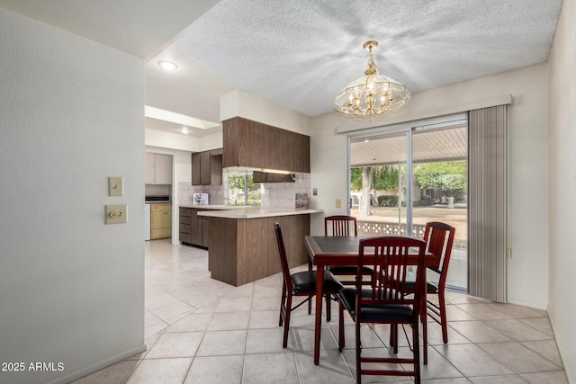 dining space featuring light tile patterned floors, a textured ceiling, baseboards, and an inviting chandelier