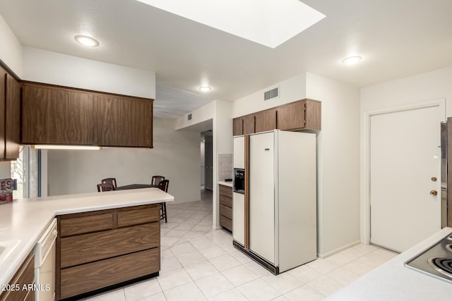 kitchen with white appliances, light tile patterned floors, visible vents, and light countertops