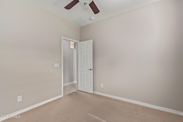 spare room with visible vents, baseboards, ceiling fan, and light colored carpet