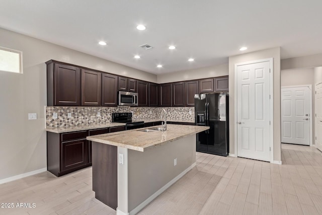 kitchen featuring visible vents, a sink, black appliances, and dark brown cabinets