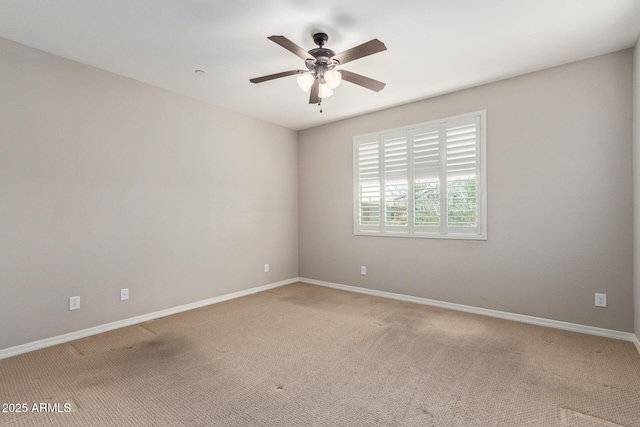 empty room featuring a ceiling fan, light carpet, and baseboards