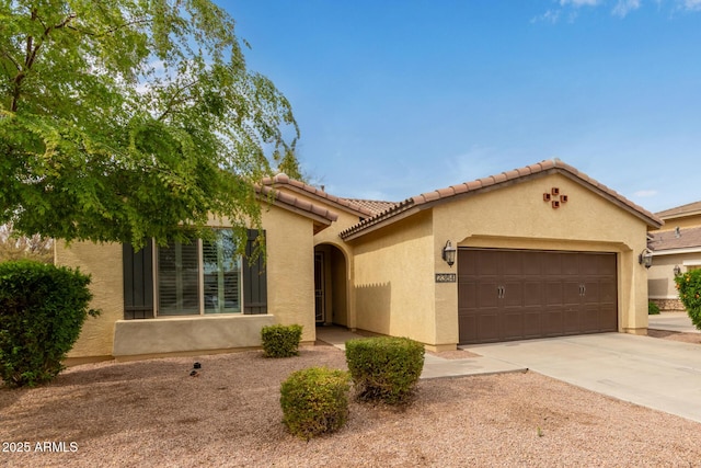 view of front of property with a garage, driveway, a tiled roof, and stucco siding