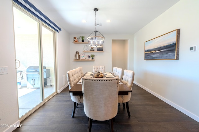 dining room with dark hardwood / wood-style floors and an inviting chandelier