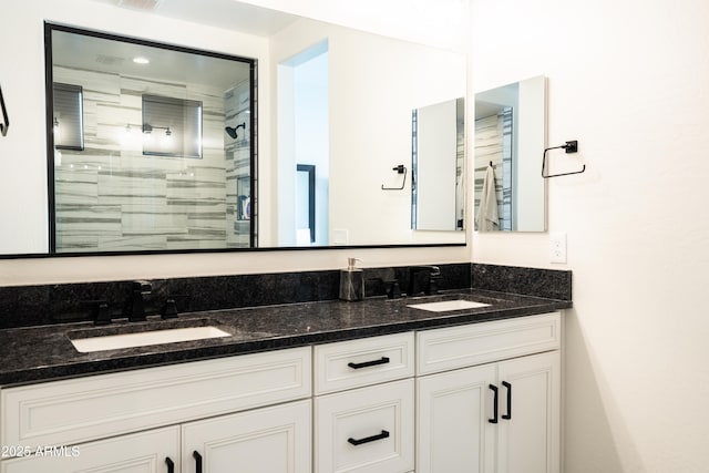 bathroom with vanity and tiled shower