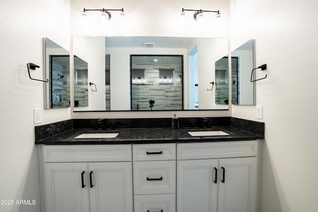 bathroom featuring a shower with door and vanity