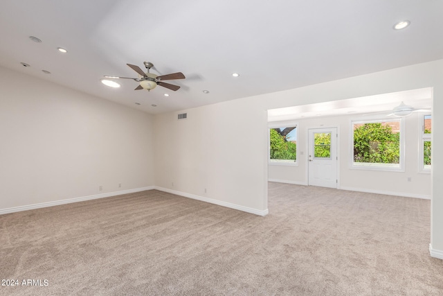 spare room with ceiling fan and light colored carpet